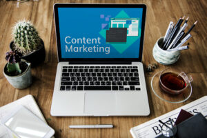 Laptop having wallpaper "content marketing" is on the table