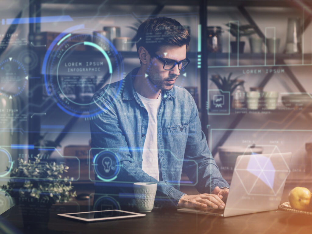 Person working on laptop sitting in a room with coffee and tablet beside