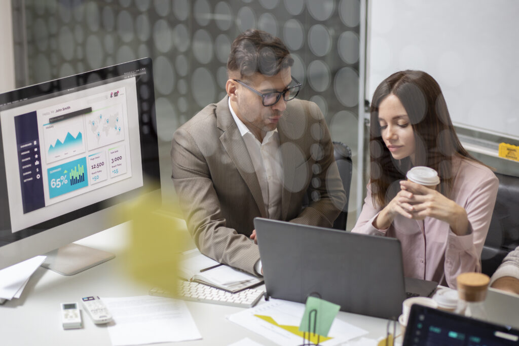 two colleagues discussing marketing funnel on laptop
