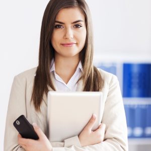 Young businesswoman holding digital tablet and mobile phone